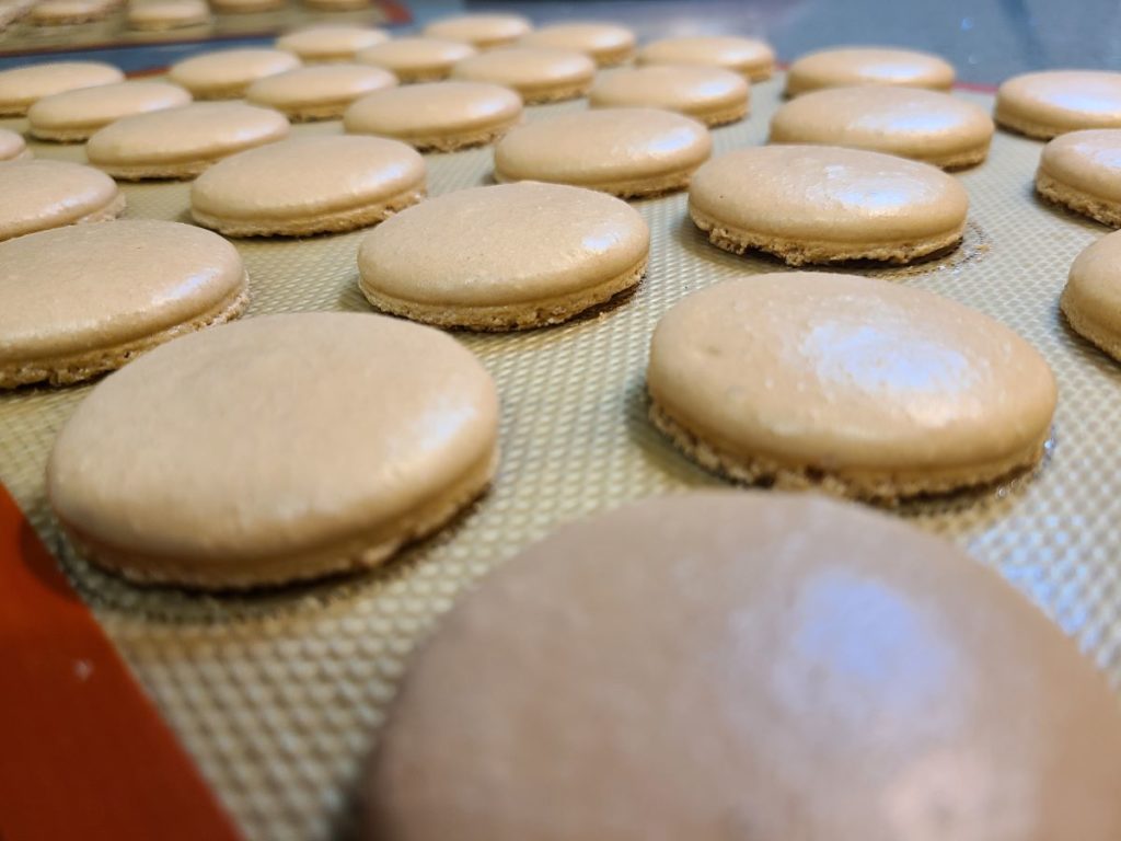 Cooked macaron shells on a silicon mat