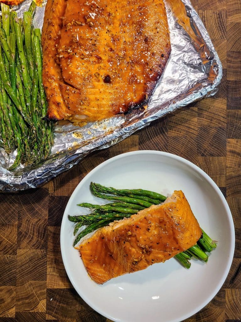 Honey glazed salmon served with remaining portions on sheet pan