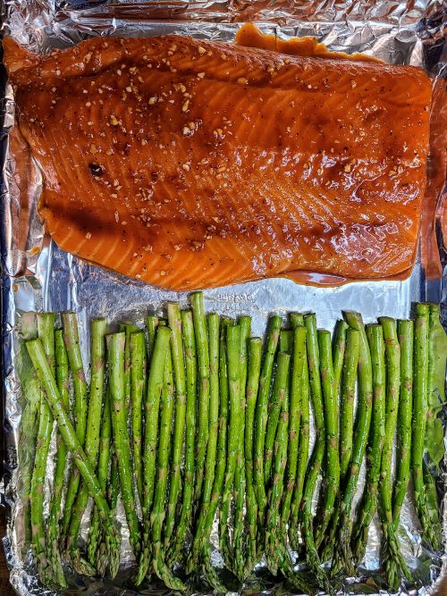 Honey glazed salmon and asparagus before being roasted on a sheet pan