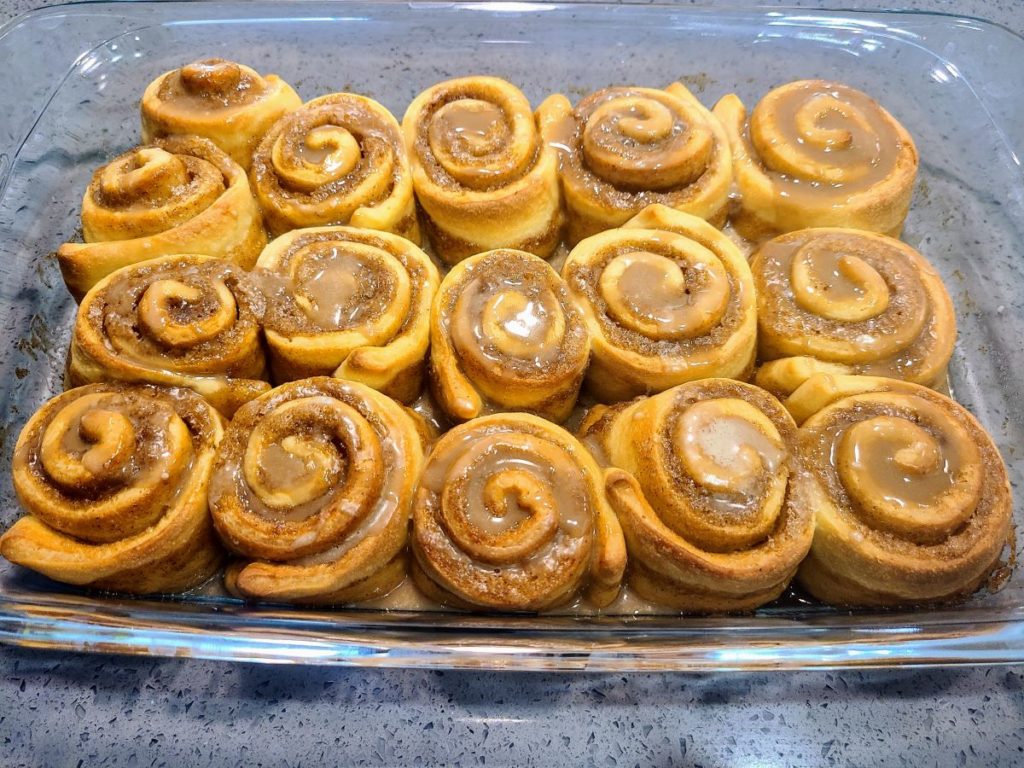 cinnamon maple rolls baked and iced in baking dish