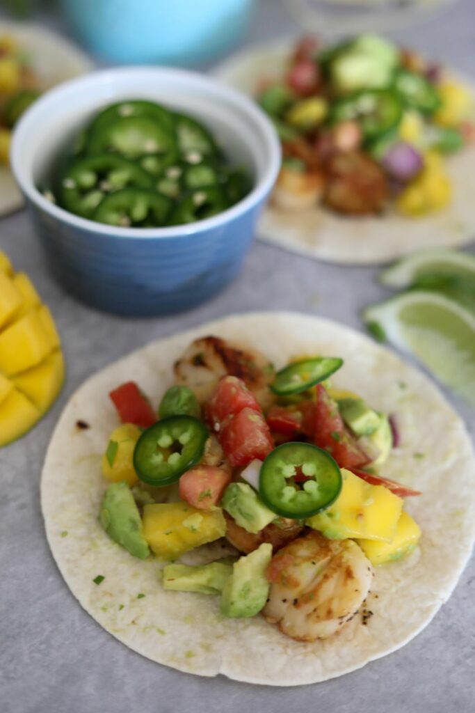 scallop taco with a cut mango and jalapeno slices