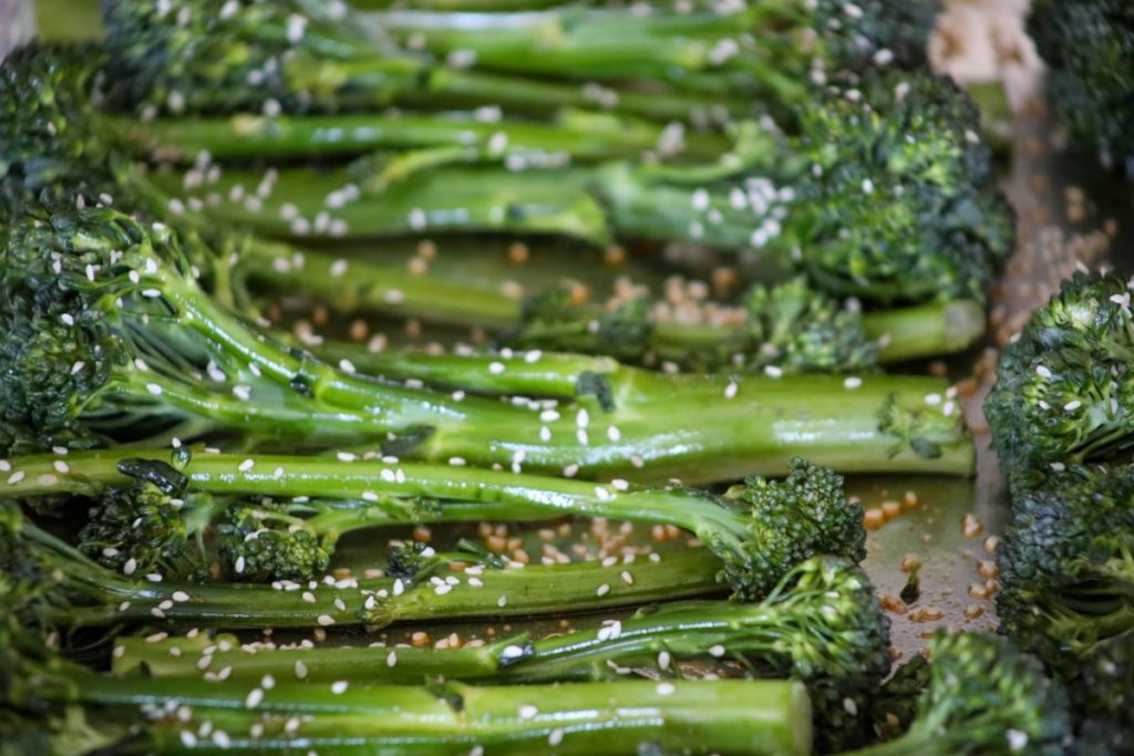 close up of uncooked broccolini on a sheet pan