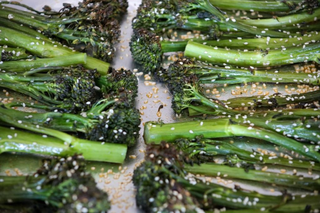 close up of roasted broccolini on a sheet pan
