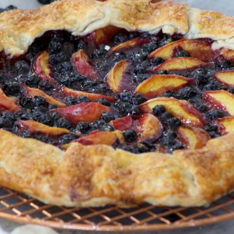 close up of a blueberry peach galette on a cooling rack