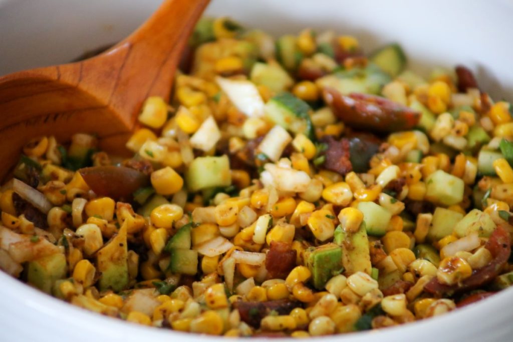 close up of corn salad in a white bowl