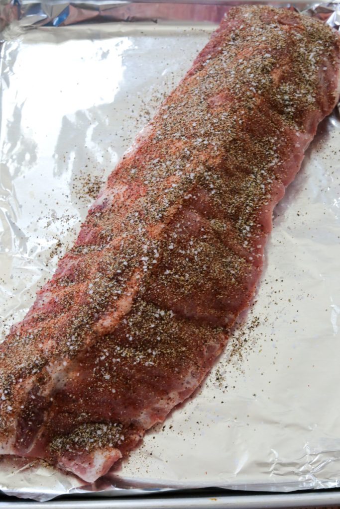 Top side of seasoned ribs on a foil lined sheet pan