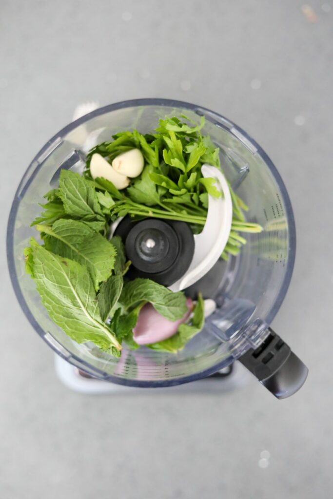 Herbs, garlic, and shallots in a food processor