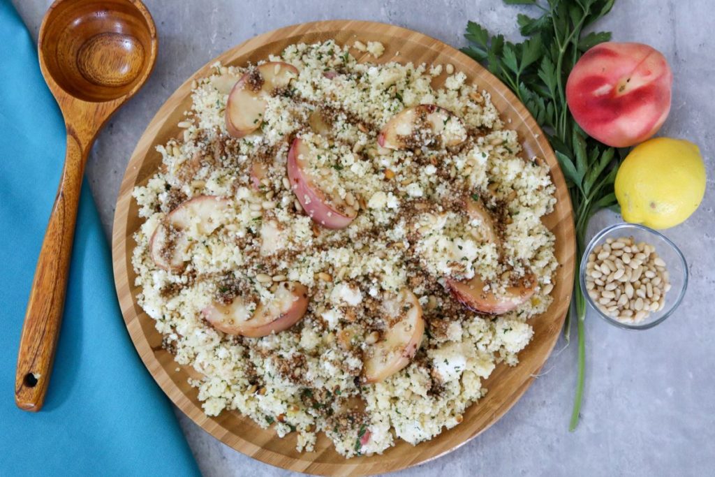 Wooden plate full of peach couscous