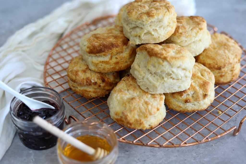 A mound of buttermilk biscuits on a cooling rack