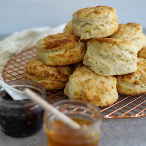 A stack of buttermilk biscuits on a cooling rack
