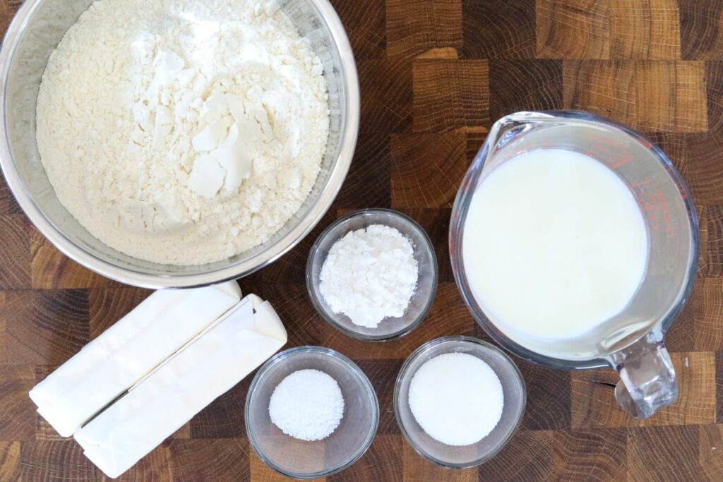Ingredients for buttermilk biscuits on a wooden cutting board
