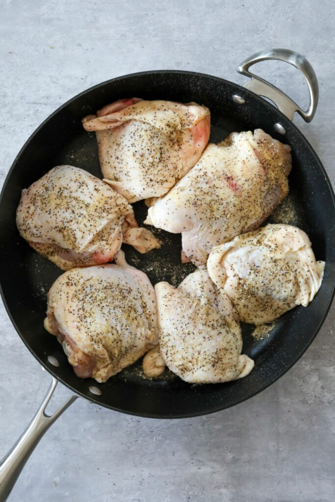 Uncooked seasoned chicken in a pan