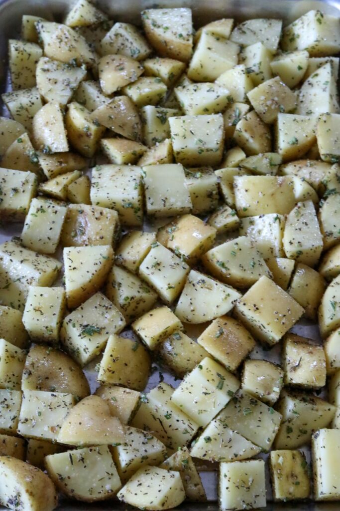 Uncooked cubed potatoes on a sheet pan