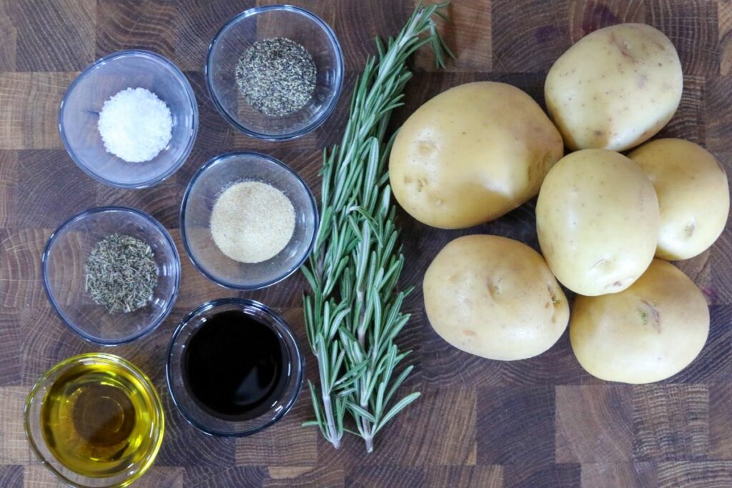 Ingredients for roasted balsamic potatoes on a wooden cutting board