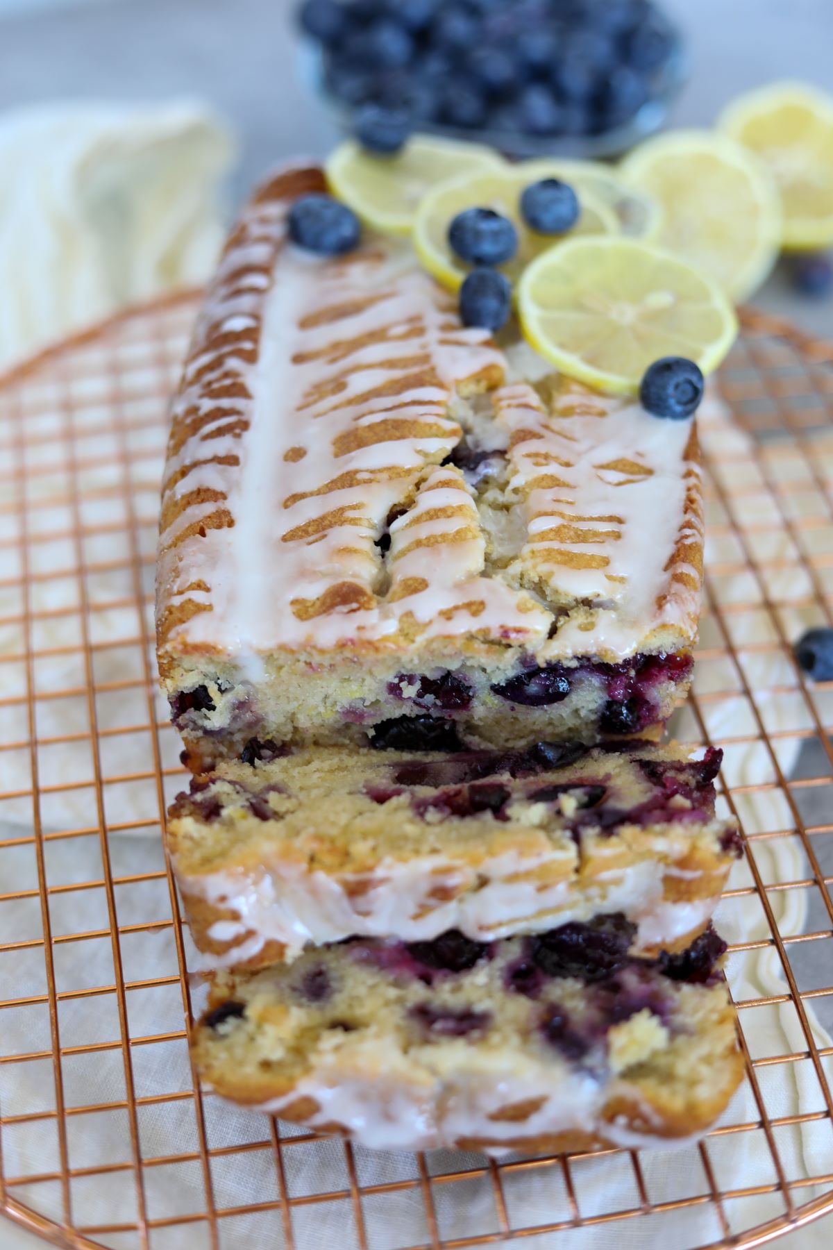 Sliced blueberry lemon loaf cake on a cooling rack