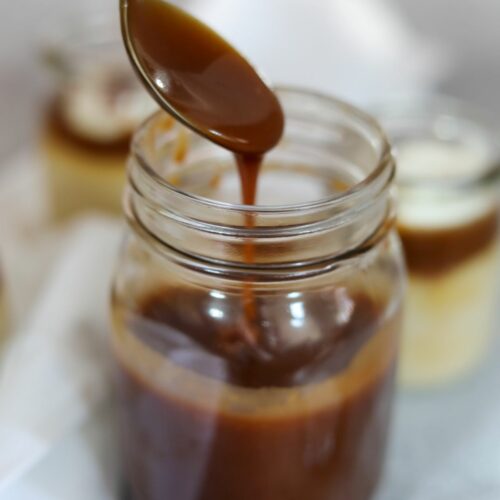 bourbon caramel sauce drizzling off of a spoon into a glass jar