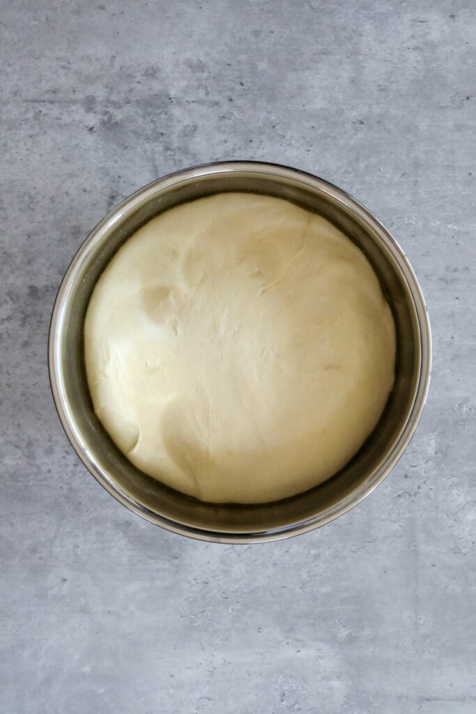 A ball of dough in a metal bowl