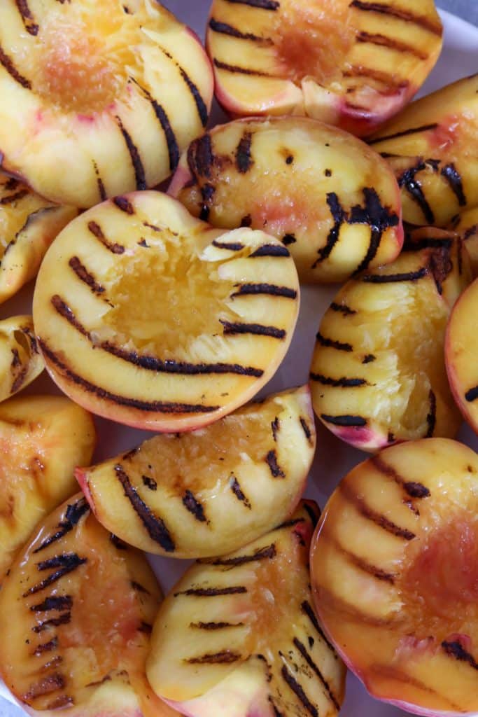 Grilled peaches on a white plate