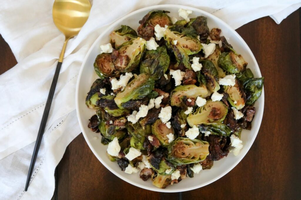 maple brussels sprouts with goat cheese on a white plate