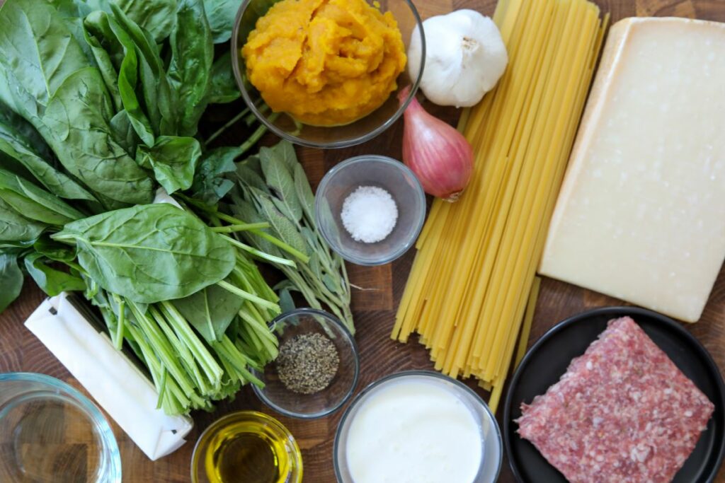 Ingredients for pumpkin pasta on a wooden cutting board