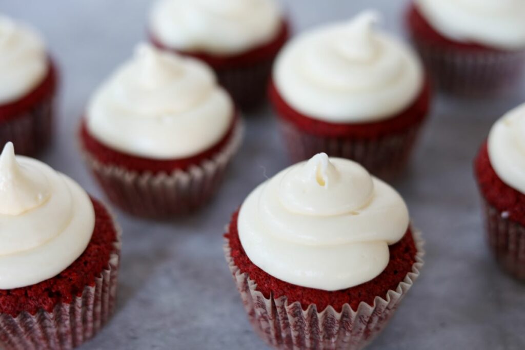Several red velvet cupcakes with frosting