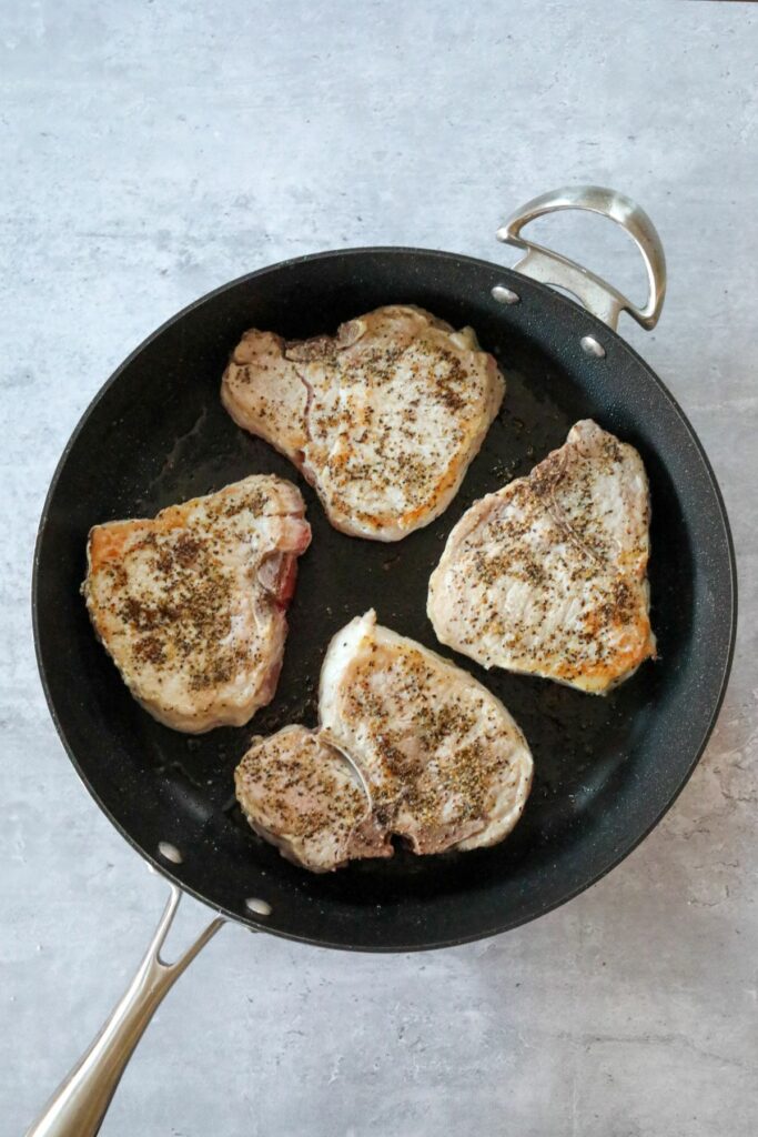 seared pork chops in a frying pan