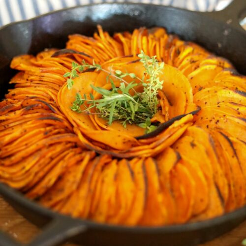 Close up of spicy roasted sweet potatoes in a cast iron skillet.