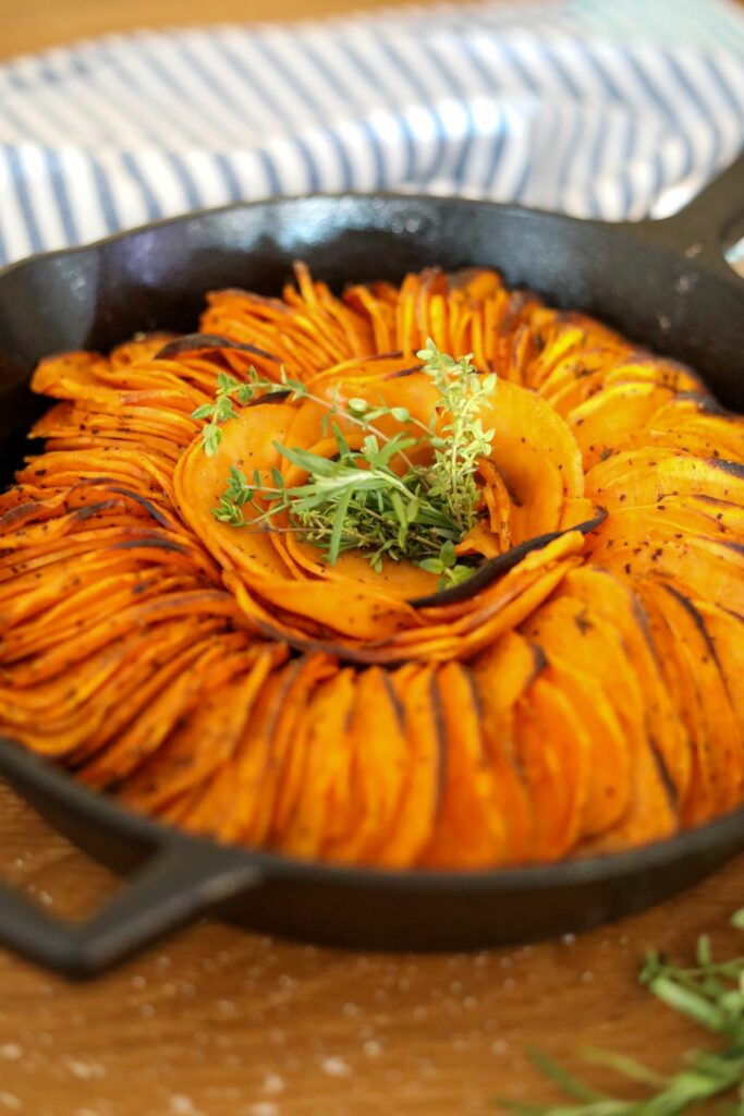 Close up of spicy roasted sweet potatoes in a cast iron skillet.