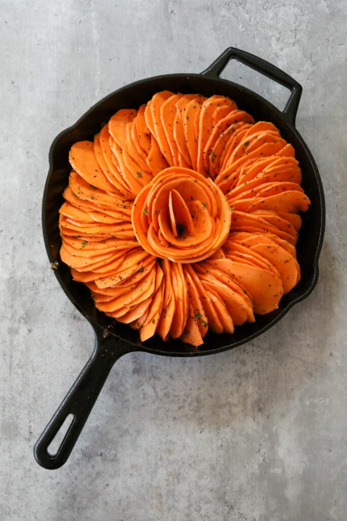 Uncooked sweet potatoes in a cast iron skillet
