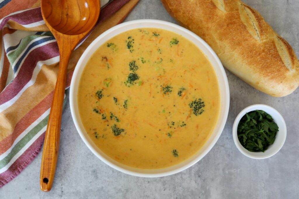 A large white bowl full of broccoli and cheddar soup