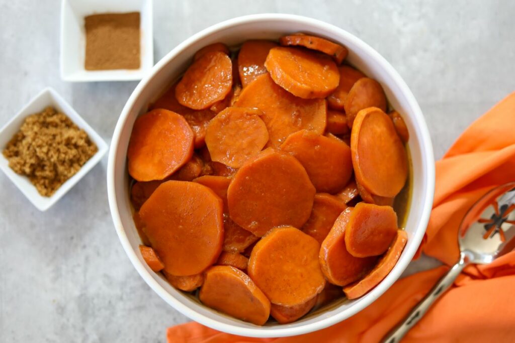 A white bowl filled with candied sweet potatoes