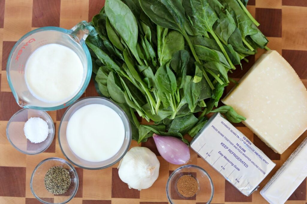Ingredients for creamed spinach on a cutting board