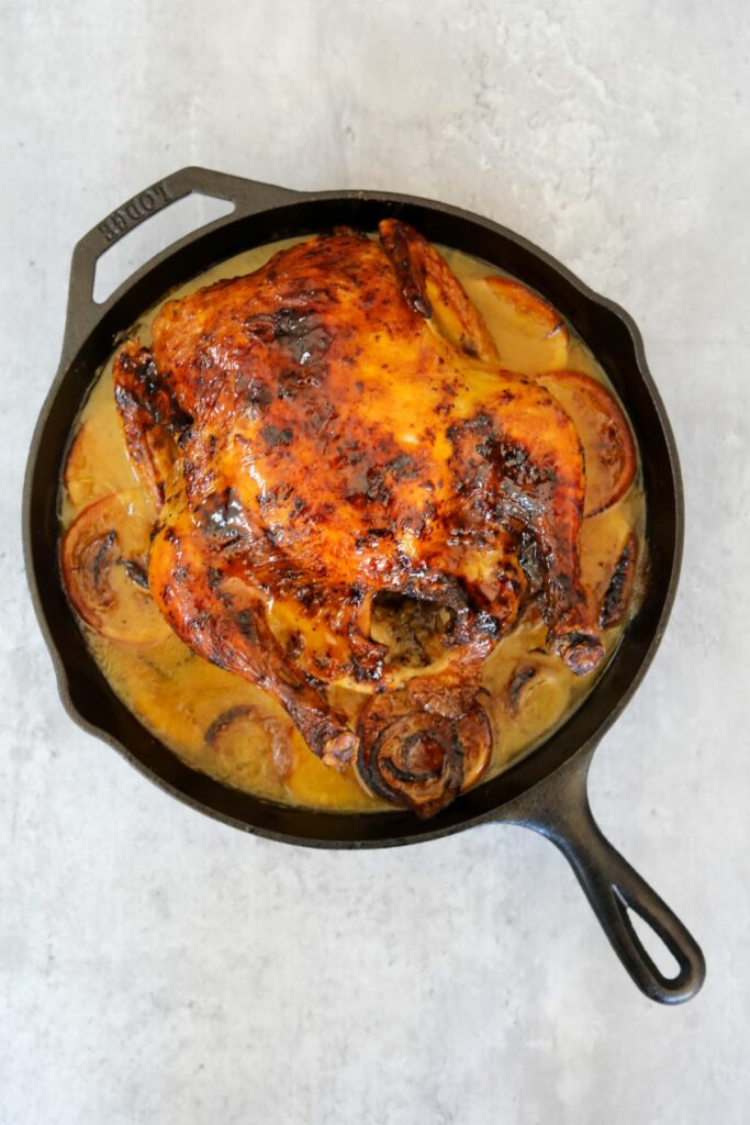baked orange glazed chicken in a cast iron skillet