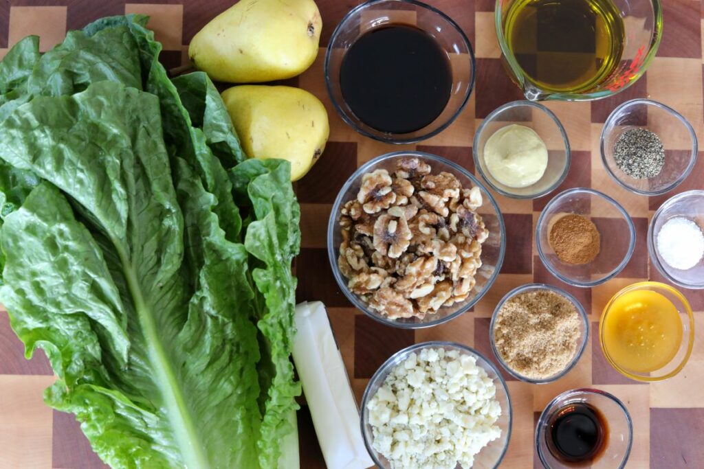 Ingredients for a pear salad on a wooden cutting board
