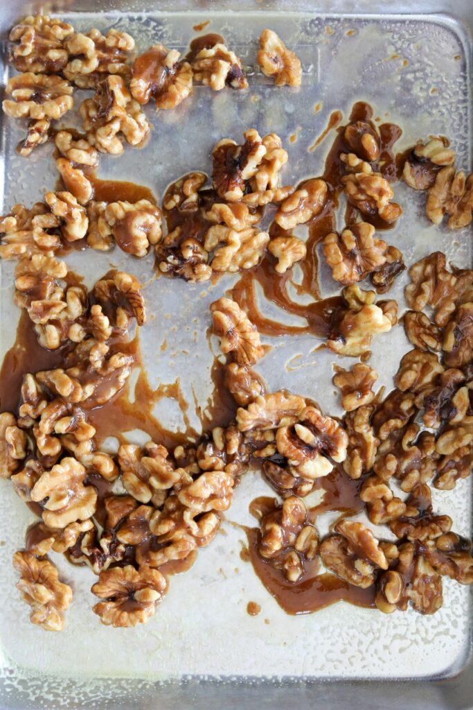 Coated walnuts on a greased sheet pan