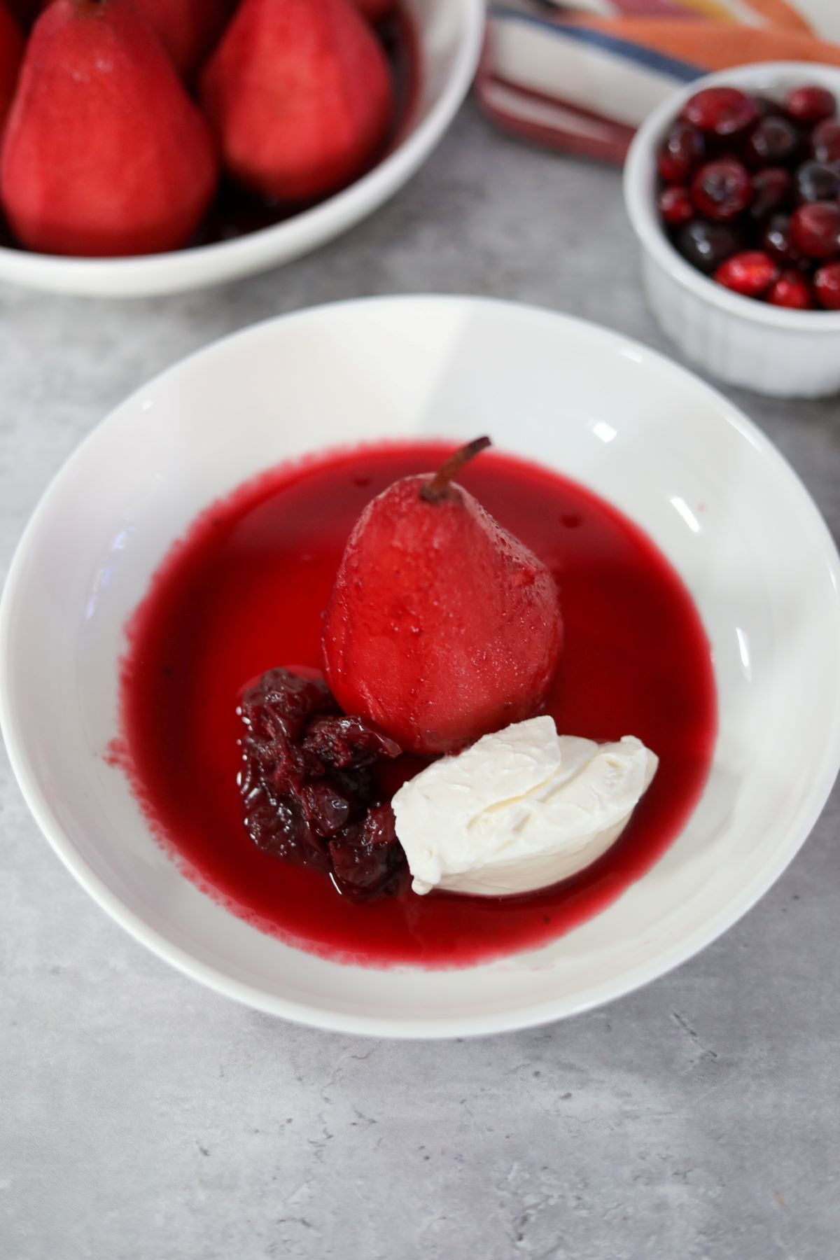 A poached pear in a white bowl