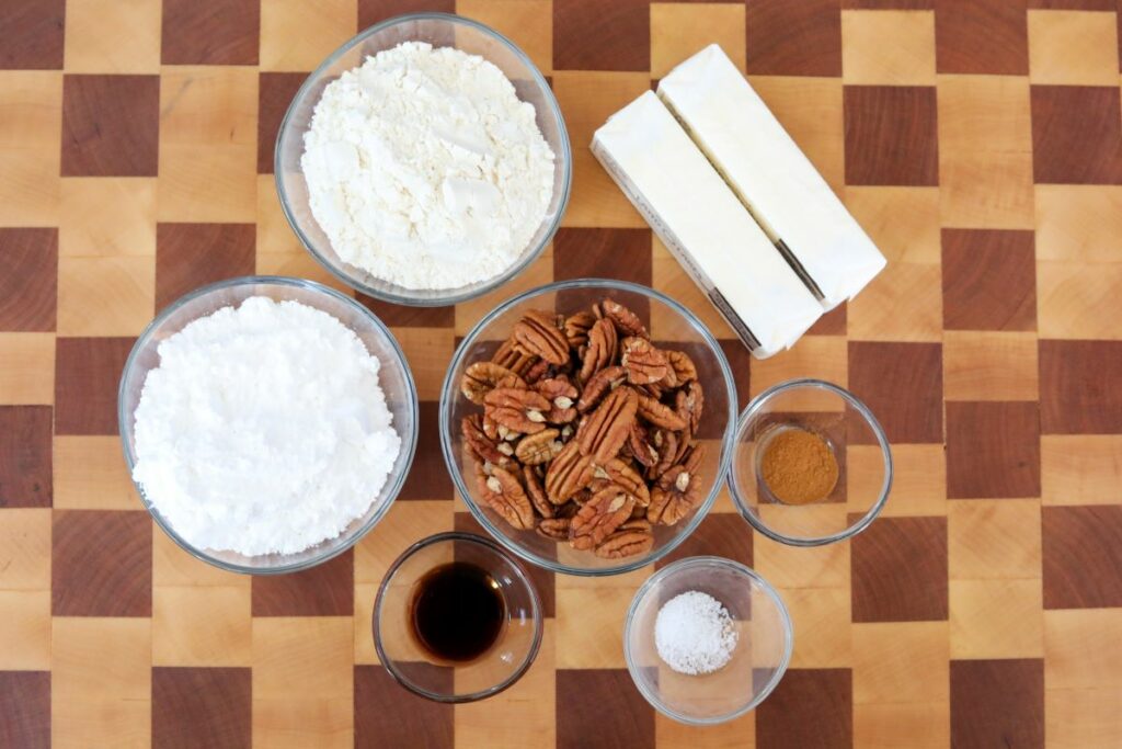 Ingredients for Mexican wedding cookies on a wooden cutting board