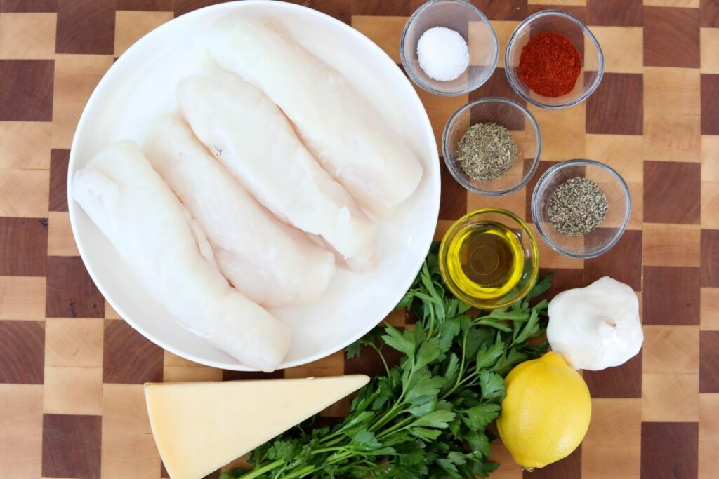 Ingredients for parmesan crusted halibut on a wooden cutting board