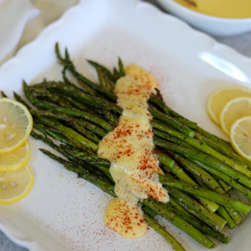 Roasted asparagus with hollandaise on a white platter