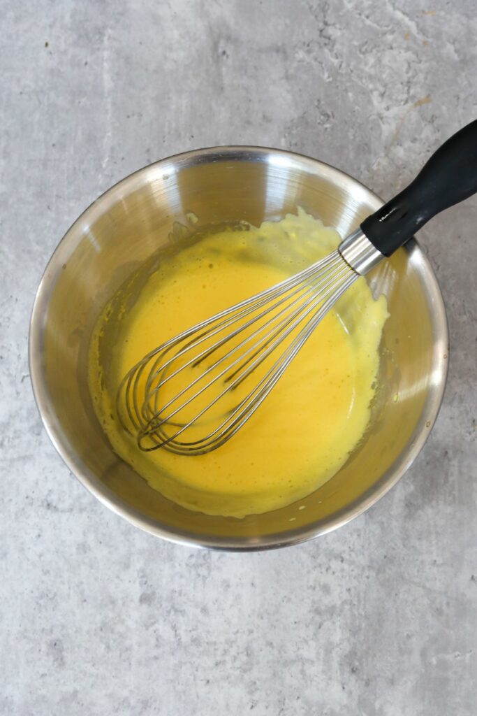 heated egg yolk mixture in a metal bowl