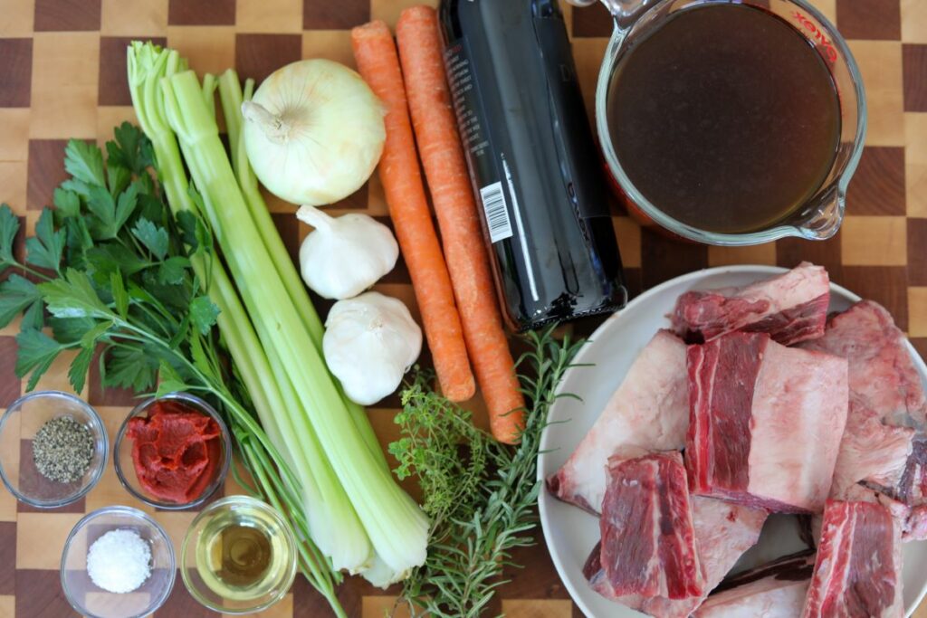 Ingredients for braised short ribs on a wooden cutting board