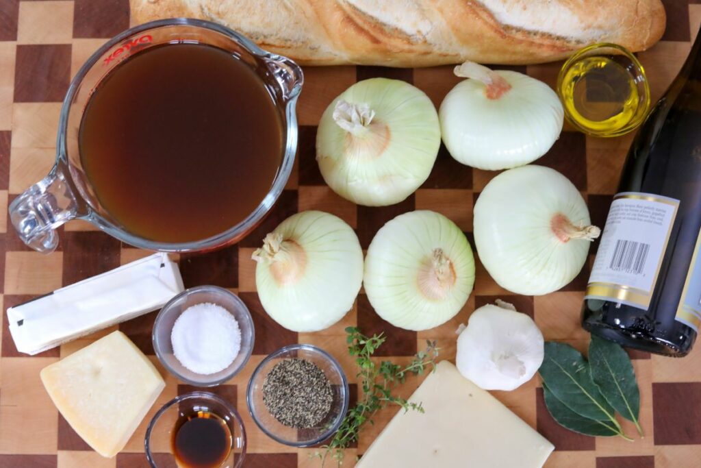 Ingredients for French onion soup on a wooden cutting board