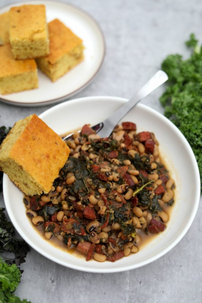 Southern black-eyed peas in a white bowl with cornbread
