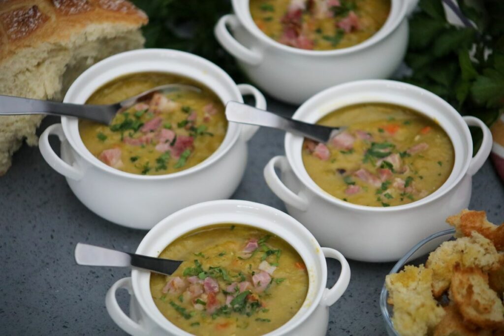 Bowls of split pea soup with spoons in them