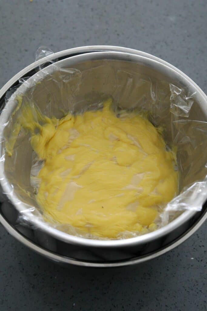 A bowl of crème patisserie with cling film on top
