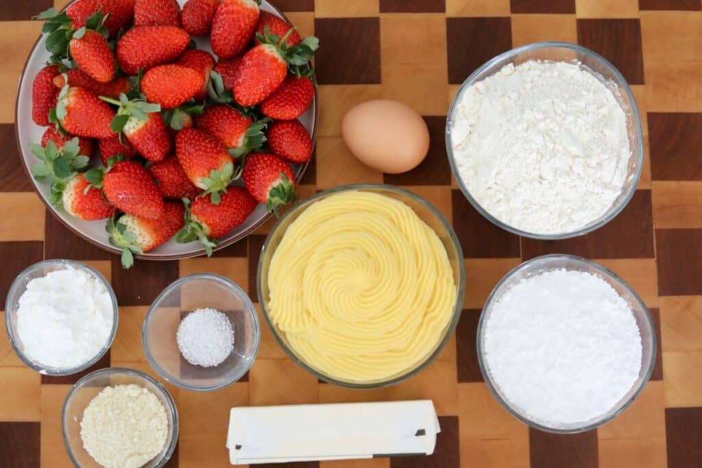 Ingredients for strawberry tart on wooden cutting board