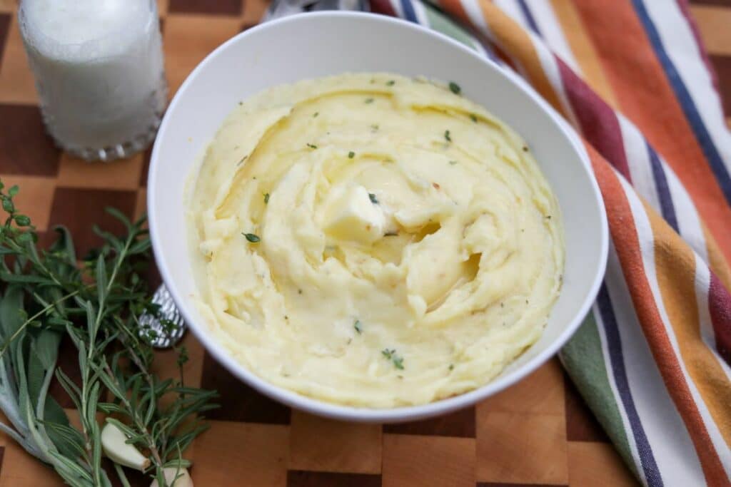 close up of a bowl of mashed potatoes with a pad of butter