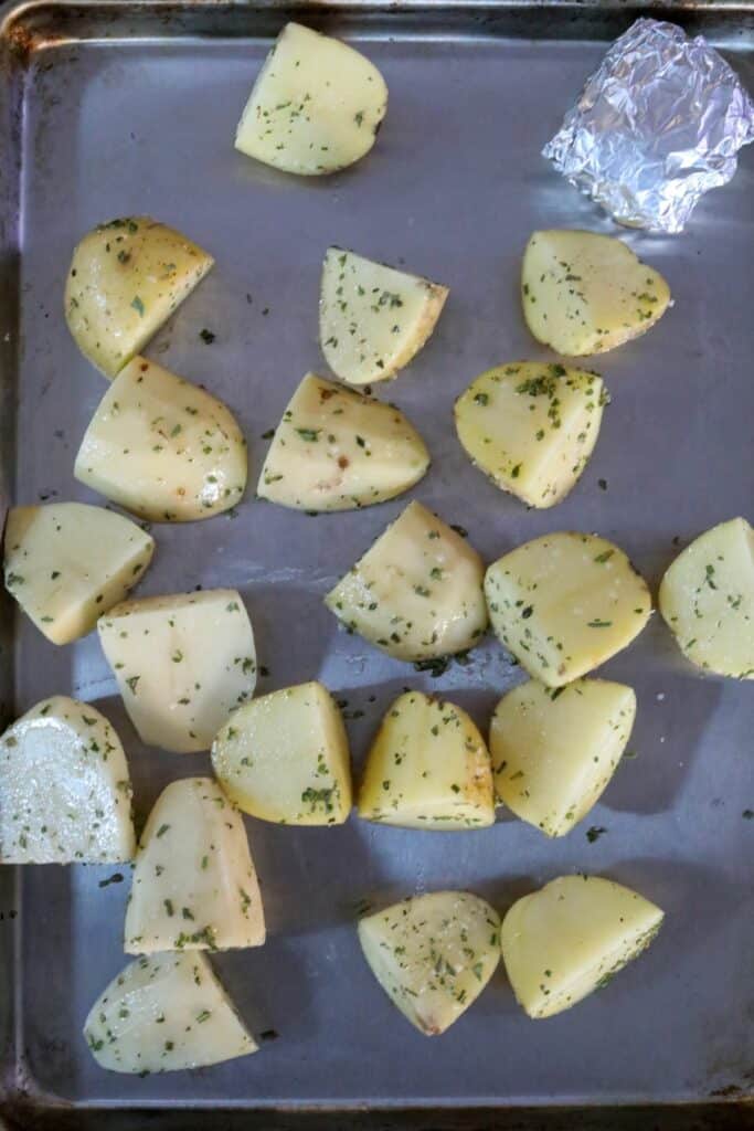 Uncooked seasoned potatoes on a sheet pan