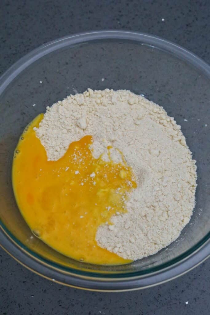 Flour mixture in a bowl with mixed egg yolk