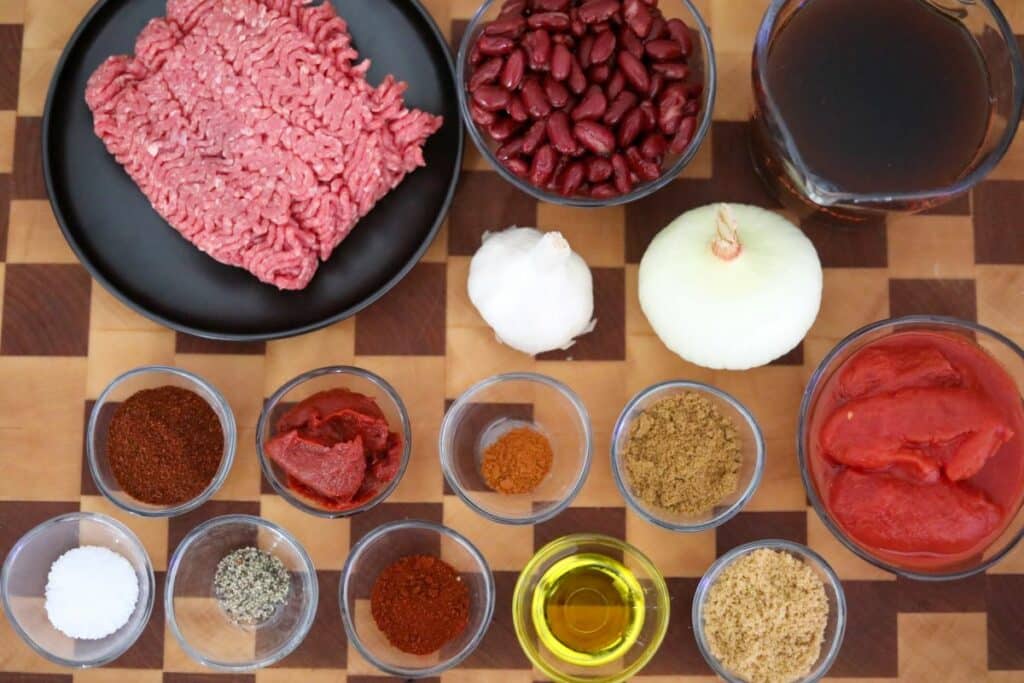 Ingredients for classic chili on a wooden cutting board